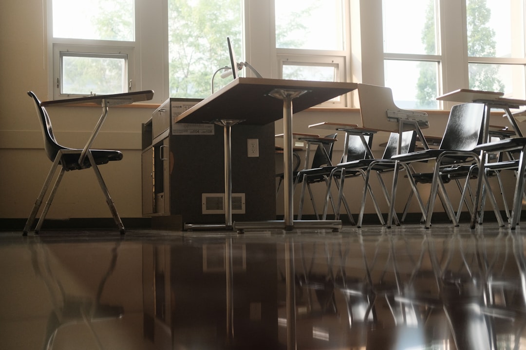 empty-classroom-with-desks-and-chairs-by-windows-vyshbugcfsu