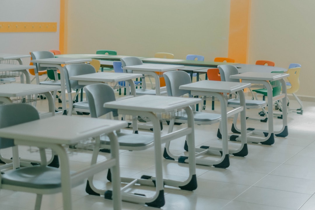 a-row-of-desks-and-chairs-in-a-room-y4pvi2pfkty